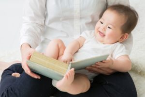 お膝の上で本を読む赤ちゃん