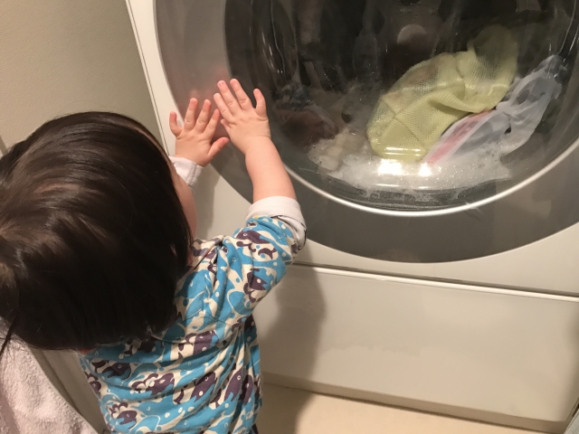 洗濯機を眺める子ども