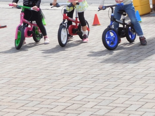 キックバイクに乗る子ども3人