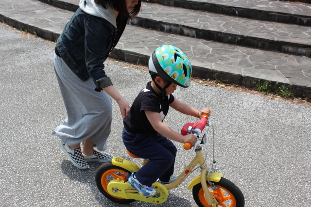 自転車の練習をする男の子とママ